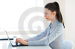 Young beautiful business woman working on laptop in the office