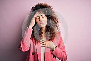 Young beautiful businesswoman with curly hair and piercing wearing elegant jacket Touching forehead for illness and fever, flu and