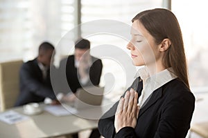 Young beautiful businesswoman enjoys meditating in office with e