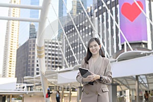 Young beautiful businesswoman is using tablet in Modern city , business technology , city lifestyle concept