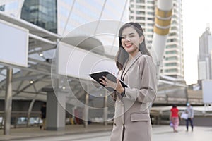 Young beautiful businesswoman is using tablet in Modern city , business technology , city lifestyle concept