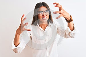 Young beautiful businesswoman wearing glasses standing over isolated white background Shouting frustrated with rage, hands trying