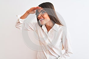 Young beautiful businesswoman wearing glasses standing over isolated white background very happy and smiling looking far away with