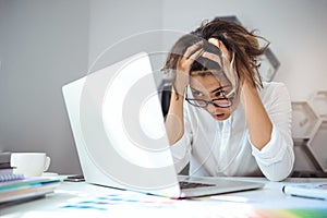 Young beautiful businesswoman working with laptop at workplace in office.