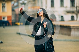 Young beautiful casual girl takes a selfie on her cell phone