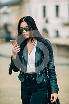 Young beautiful casual woman texting/calling on her cell phone