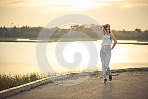 Young beautiful caucasian blonde girl listening to music with smartphone walking and dance in the city with headphones