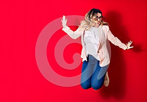 Young beautiful caucasian businesswoman wearing jacket and glasses smiling happy