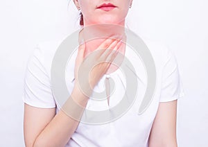 Young beautiful caucasian girl holding her throat, the concept of a tumor and bacterial tonsillitis, tonsillitis photo