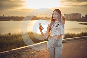 Young beautiful caucasian girl listening to music with smartphone walking in the city with headphones smiling - relax, youth,