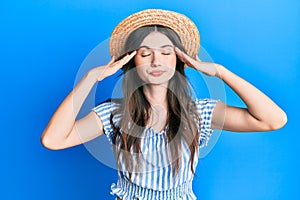 Young beautiful caucasian girl wearing summer hat with hand on head, headache because stress