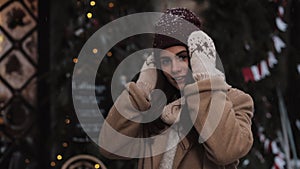 Young Beautiful Caucasian Girl Wearing Winter Clothes, Putting Hat Straight and Smiling Looking to camera Walking in