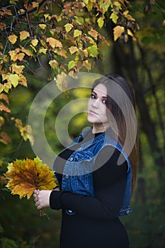 Young beautiful caucasian plus size model in jeans vest outdoors, xxl woman on nature, autumn atmosphere