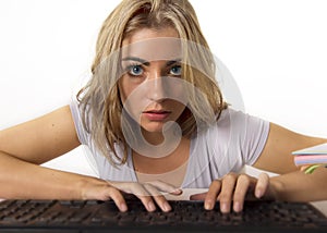 Young beautiful Caucasian student girl or working woman typing on computer keyboard looking focused and concentrated in hard work