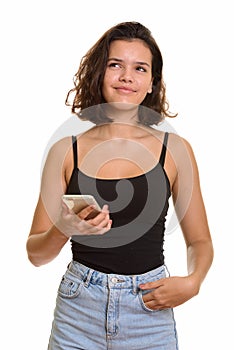 Young beautiful Caucasian teenage girl holding mobile phone whil