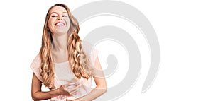 Young beautiful caucasian woman with blond hair wearing casual clothes smiling and laughing hard out loud because funny crazy joke