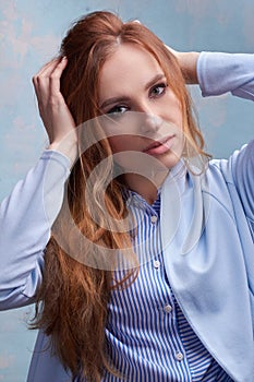 Young beautiful Caucasian woman, in a blue suit, on a blue background