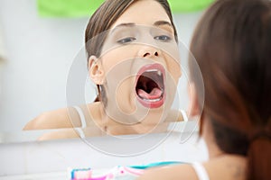 Young beautiful caucasian woman checking throat