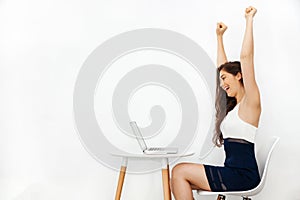 Young beautiful Caucasian woman having arms raised up as she has won over something in white isolated background with copy space