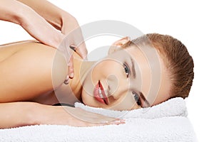 Young beautiful caucasian woman lying on a massage table and is