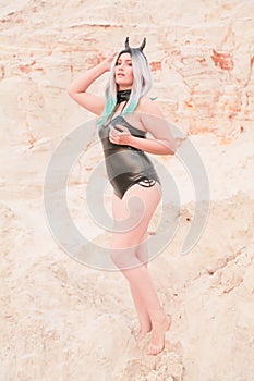 Young beautiful Caucasian woman posing in desert landscape with sand.