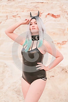 Young beautiful Caucasian woman posing in desert landscape with sand.