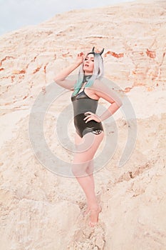 Young beautiful Caucasian woman posing in desert landscape with sand.