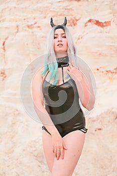 Young beautiful Caucasian woman posing in desert landscape with sand.