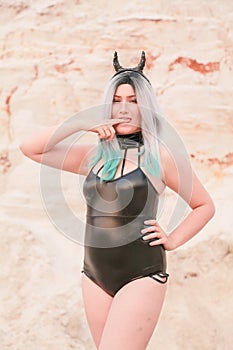 Young beautiful Caucasian woman posing in desert landscape with sand.