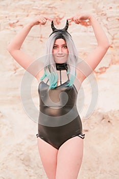 Young beautiful Caucasian woman posing in desert landscape with sand.