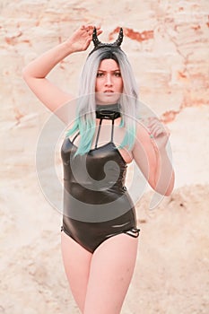 Young beautiful Caucasian woman posing in desert landscape with sand.