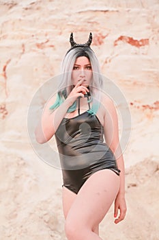 Young beautiful Caucasian woman posing in desert landscape with sand.