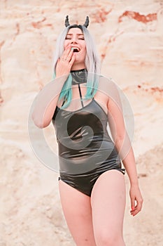 Young beautiful Caucasian woman posing in desert landscape with sand.