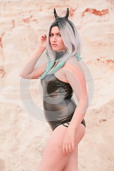 Young beautiful Caucasian woman posing in desert landscape with sand.