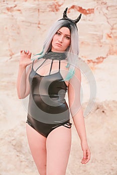 Young beautiful Caucasian woman posing in desert landscape with sand.