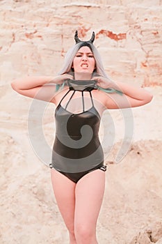 Young beautiful Caucasian woman posing in desert landscape with sand.