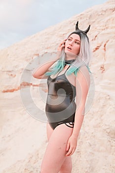 Young beautiful Caucasian woman posing in desert landscape with sand.