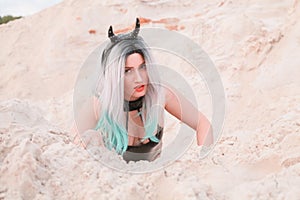 Young beautiful Caucasian woman posing in desert landscape with sand.