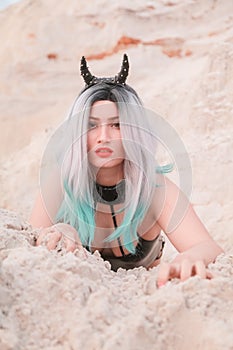 Young beautiful Caucasian woman posing in desert landscape with sand.