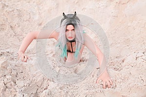 Young beautiful Caucasian woman posing in desert landscape with sand.