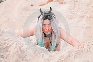 Young beautiful Caucasian woman posing in desert landscape with sand.