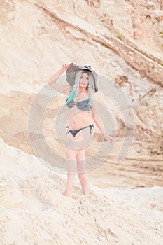 Young beautiful Caucasian woman posing in desert landscape with sand.