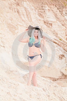 Young beautiful Caucasian woman posing in desert landscape with sand.