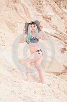 Young beautiful Caucasian woman posing in desert landscape with sand.