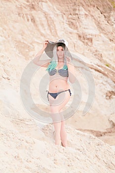 Young beautiful Caucasian woman posing in desert landscape with sand.