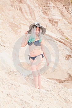 Young beautiful Caucasian woman posing in desert landscape with sand.