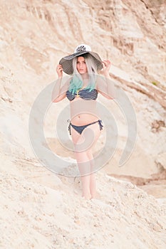 Young beautiful Caucasian woman posing in desert landscape with sand.