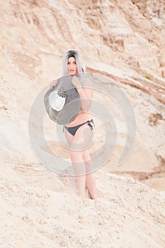 Young beautiful Caucasian woman posing in desert landscape with sand.