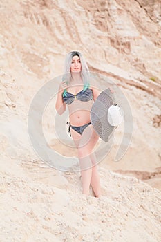 Young beautiful Caucasian woman posing in desert landscape with sand.