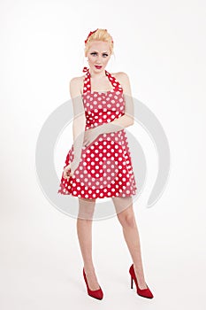 Young beautiful caucasian woman posing in a pin up red dress style